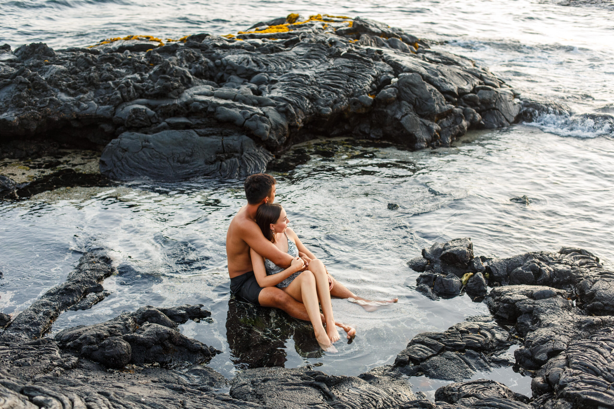 a couple sitting in the ocean together after their Hawaiian elopement
