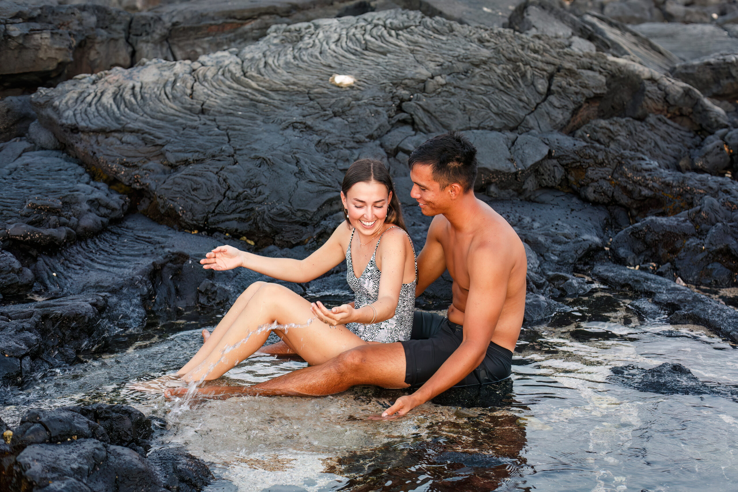 a couple playing together in the ocean in Hawaii