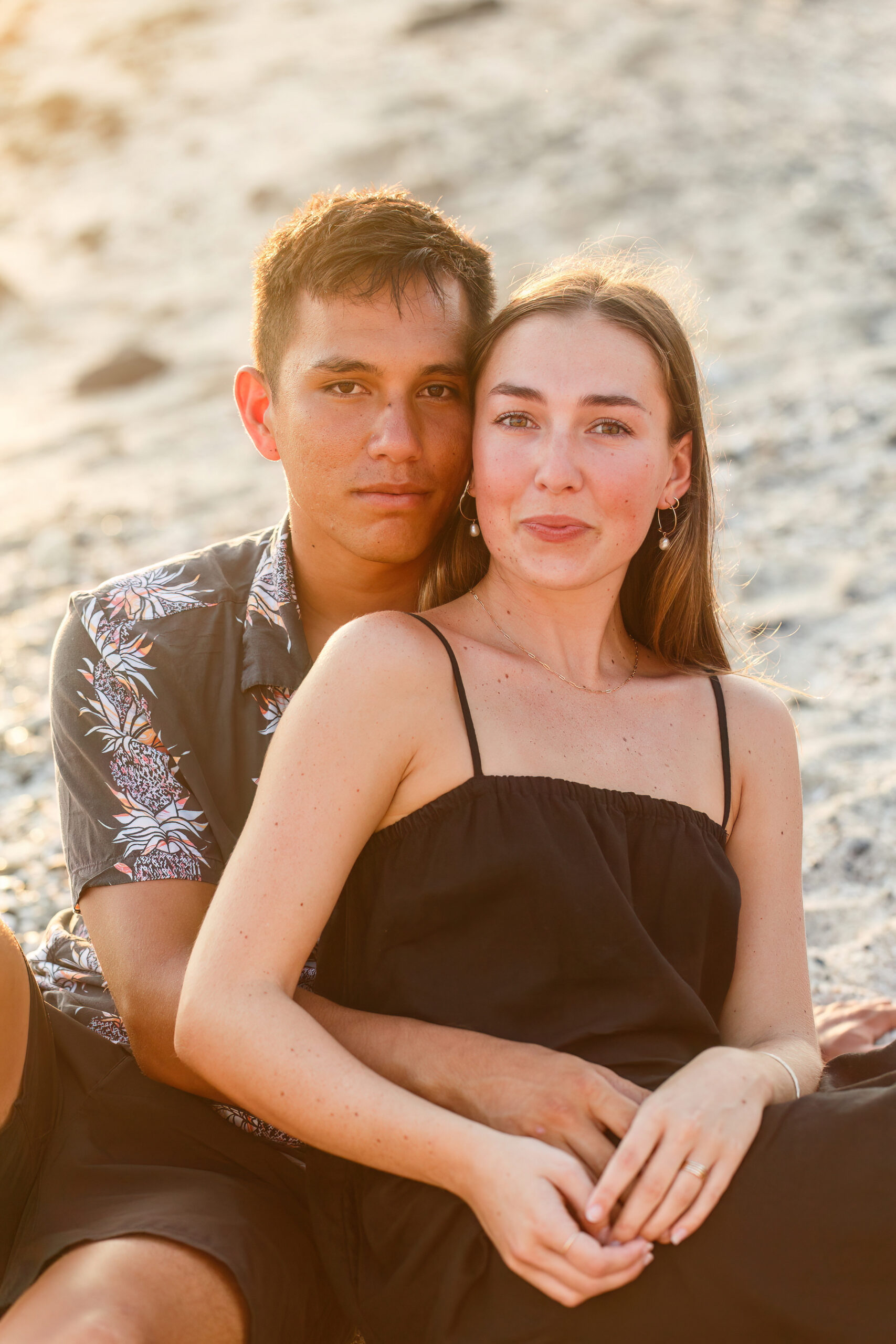 a couple sitting together on a beach in Hawaii