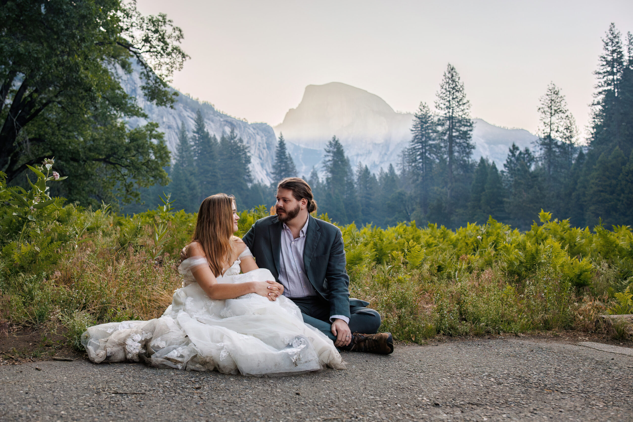 newly weds sitting on the ground together in Yosemite soaking in the moment of being just married