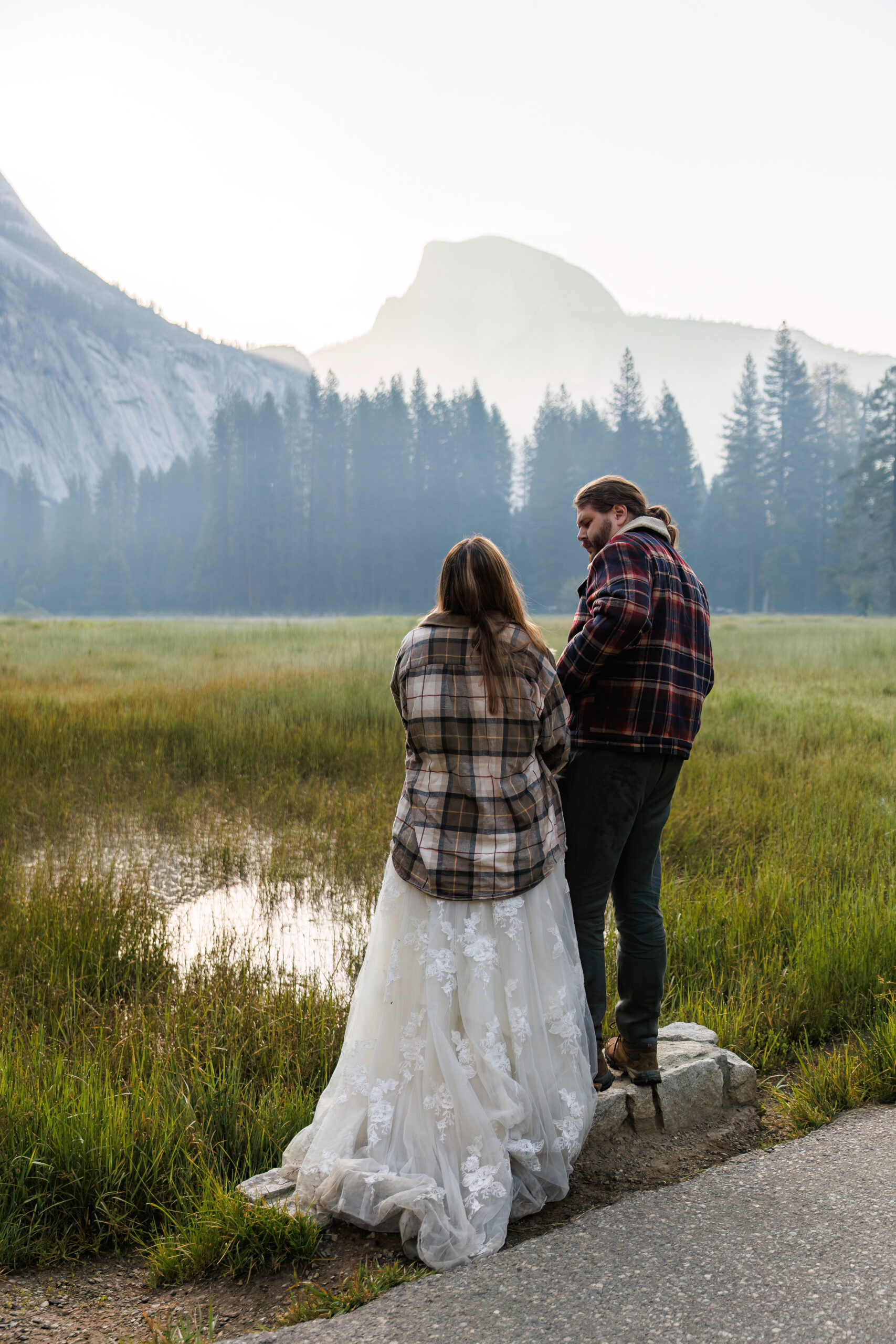 newly weds wearing flannels in Yosemite as the sun starts to come up