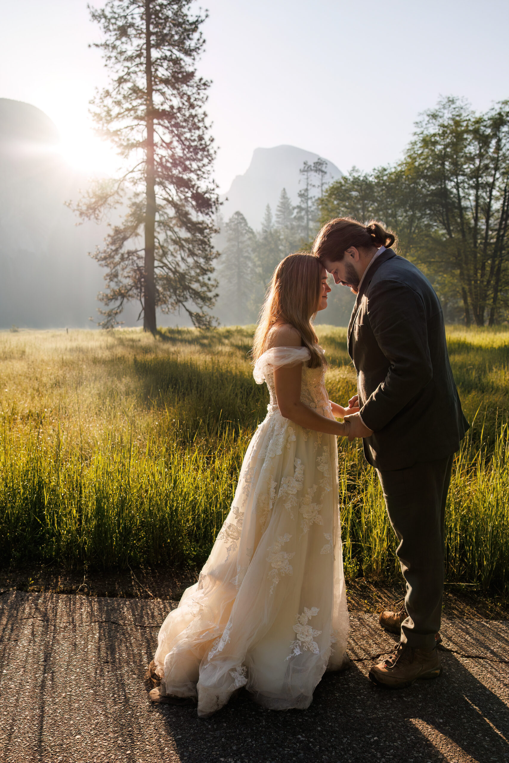newly weds holding hands and leaning into each other during Yosemite wedding photos