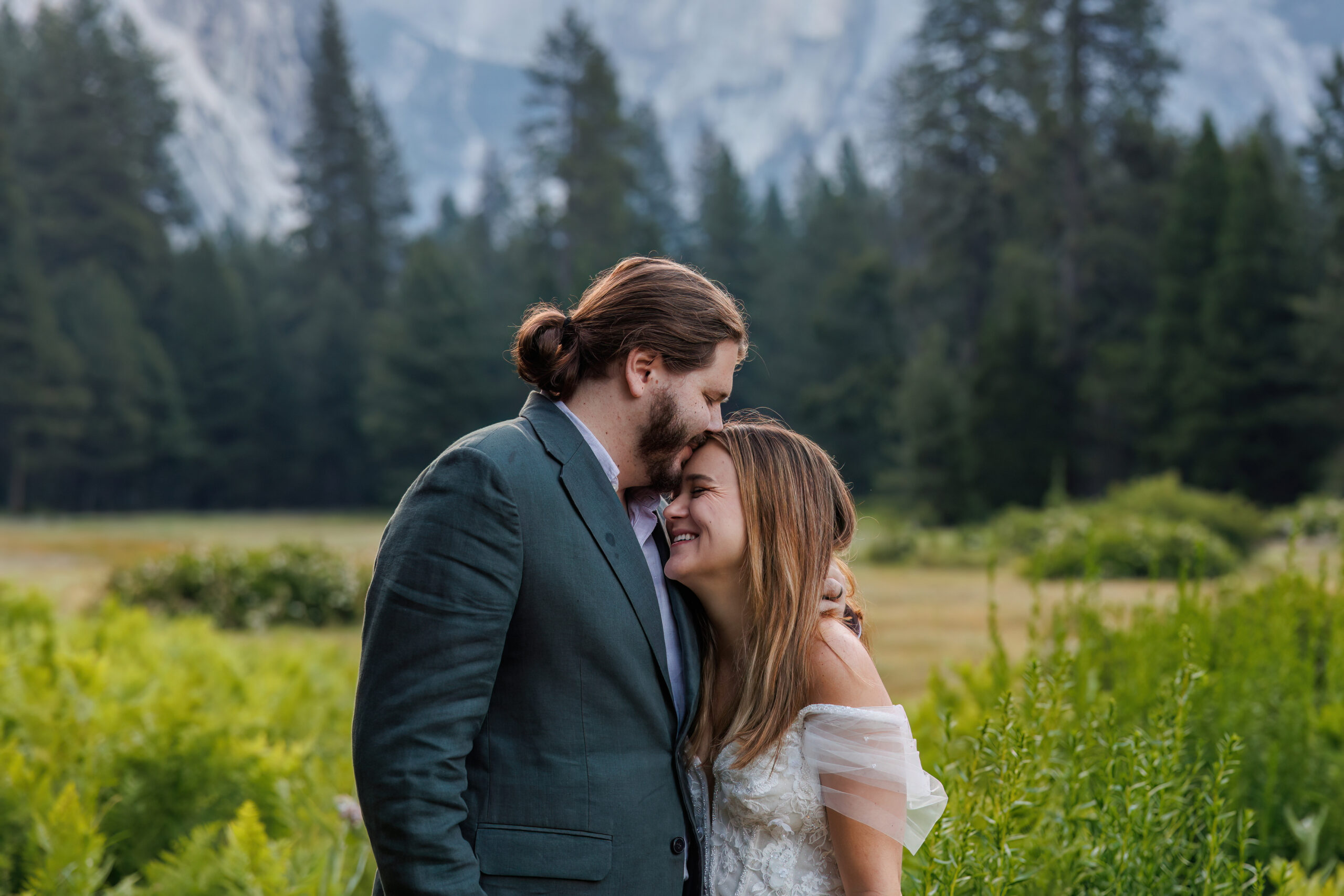a man kissing a woman on her head during Yosemite wedding photos