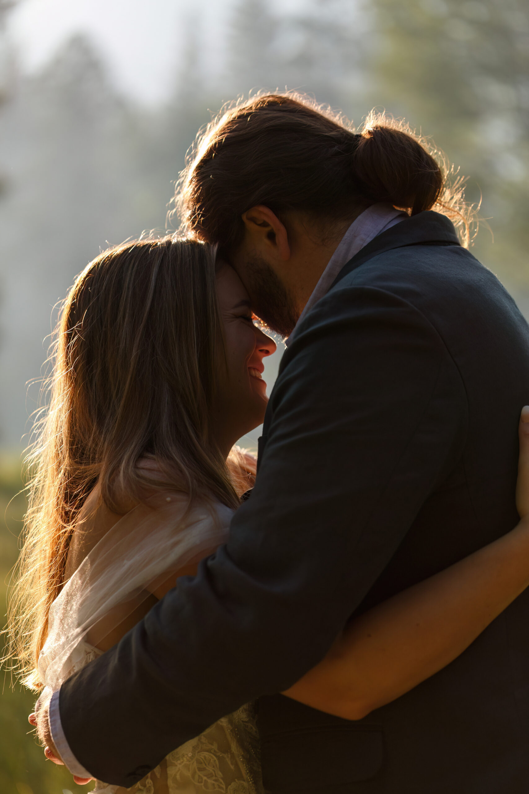 a couple leaning their faces into each other as they embrace