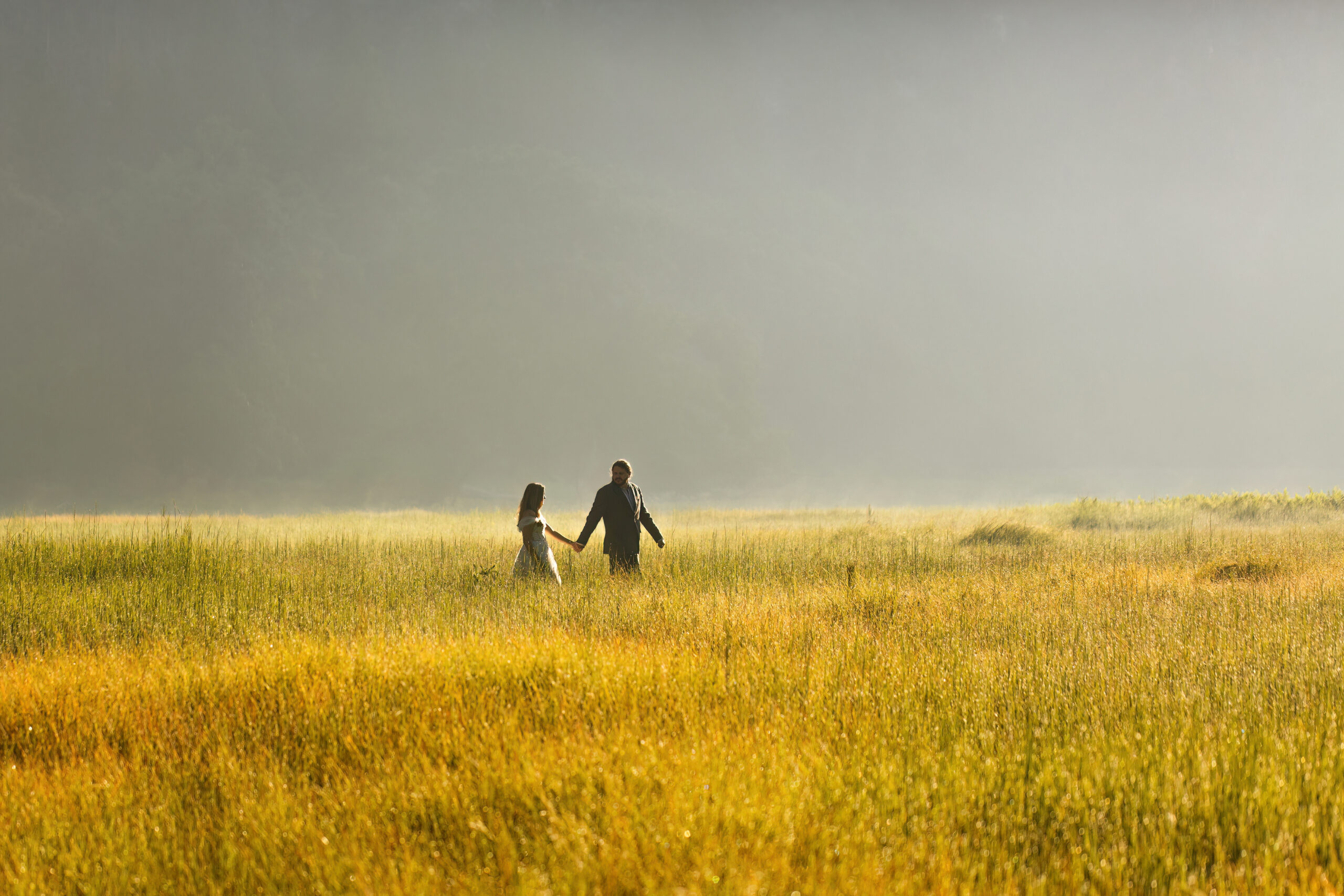 newly weds walking through the grass for Yosemite wedding photos
