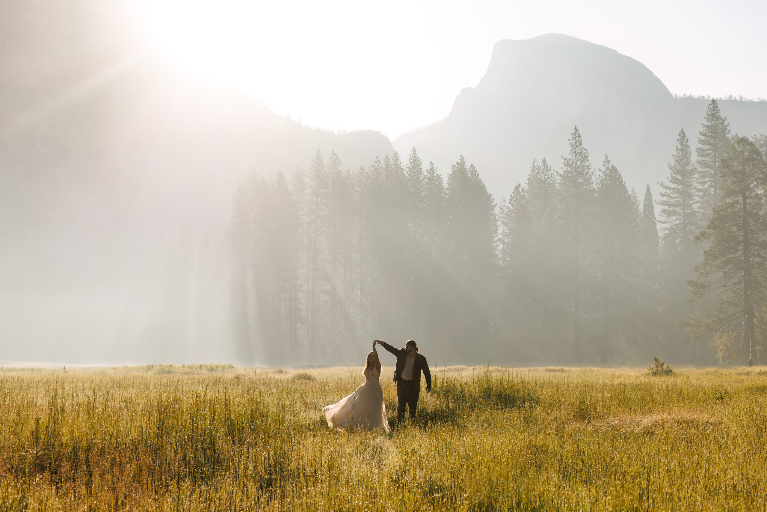 newly weds dancing in the misty valley in Yosemite