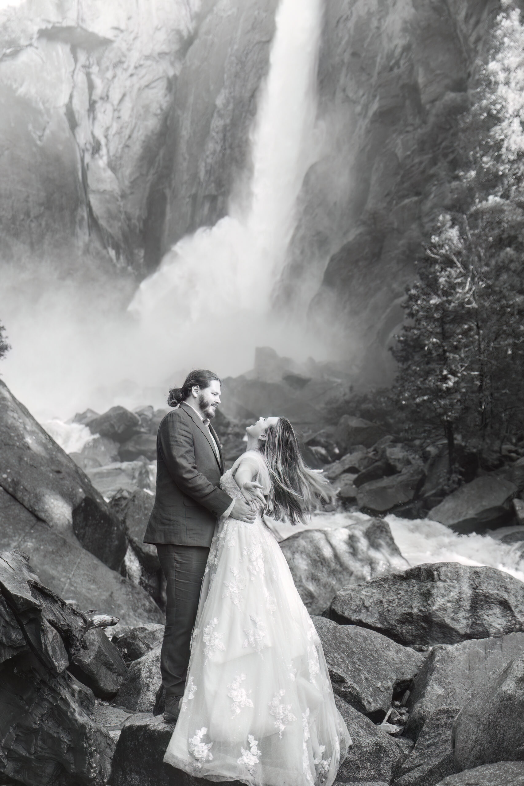a couple standing by a waterfall taking in the moment together