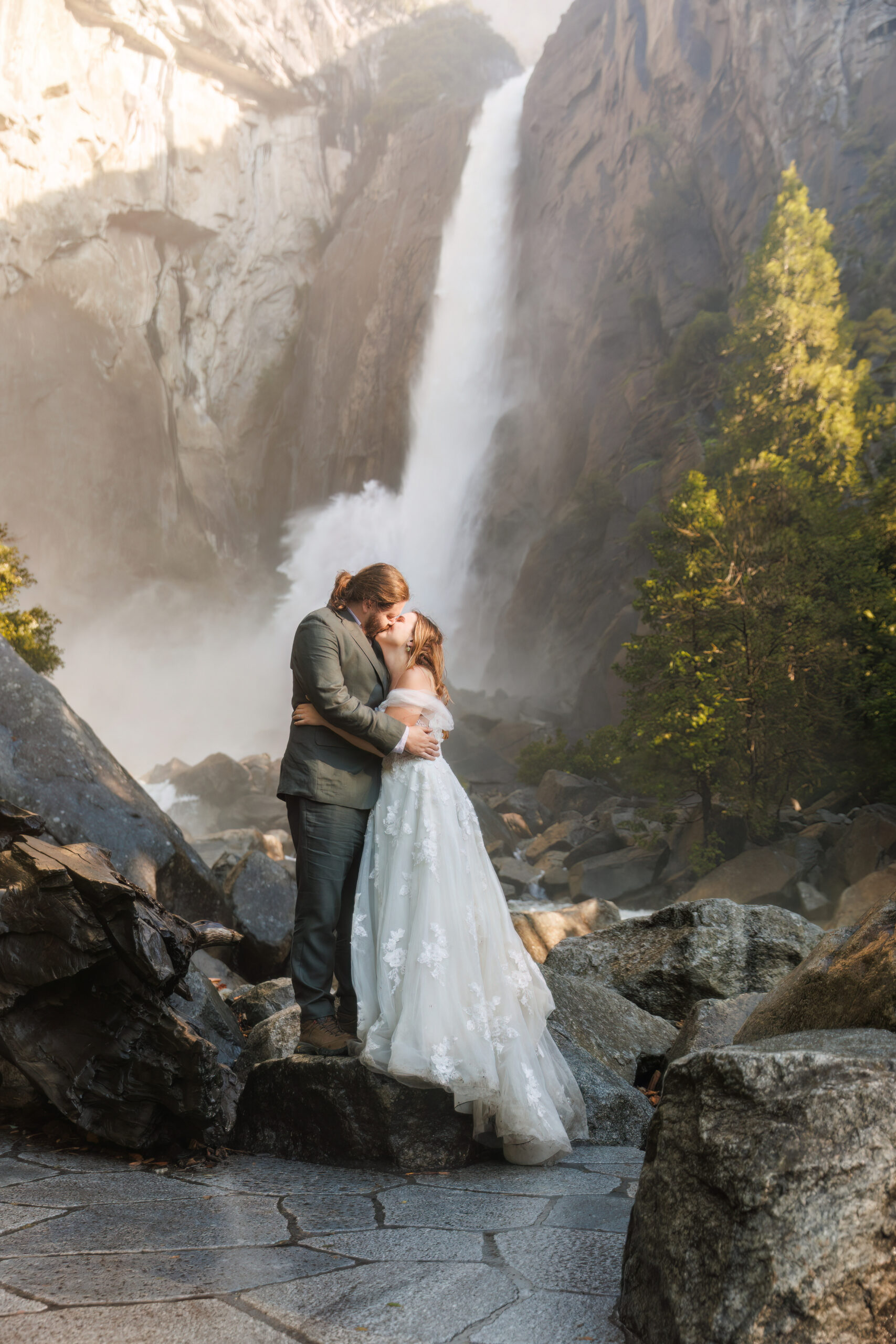 newly weds kissing by a waterfall for Yosemite wedding photos
