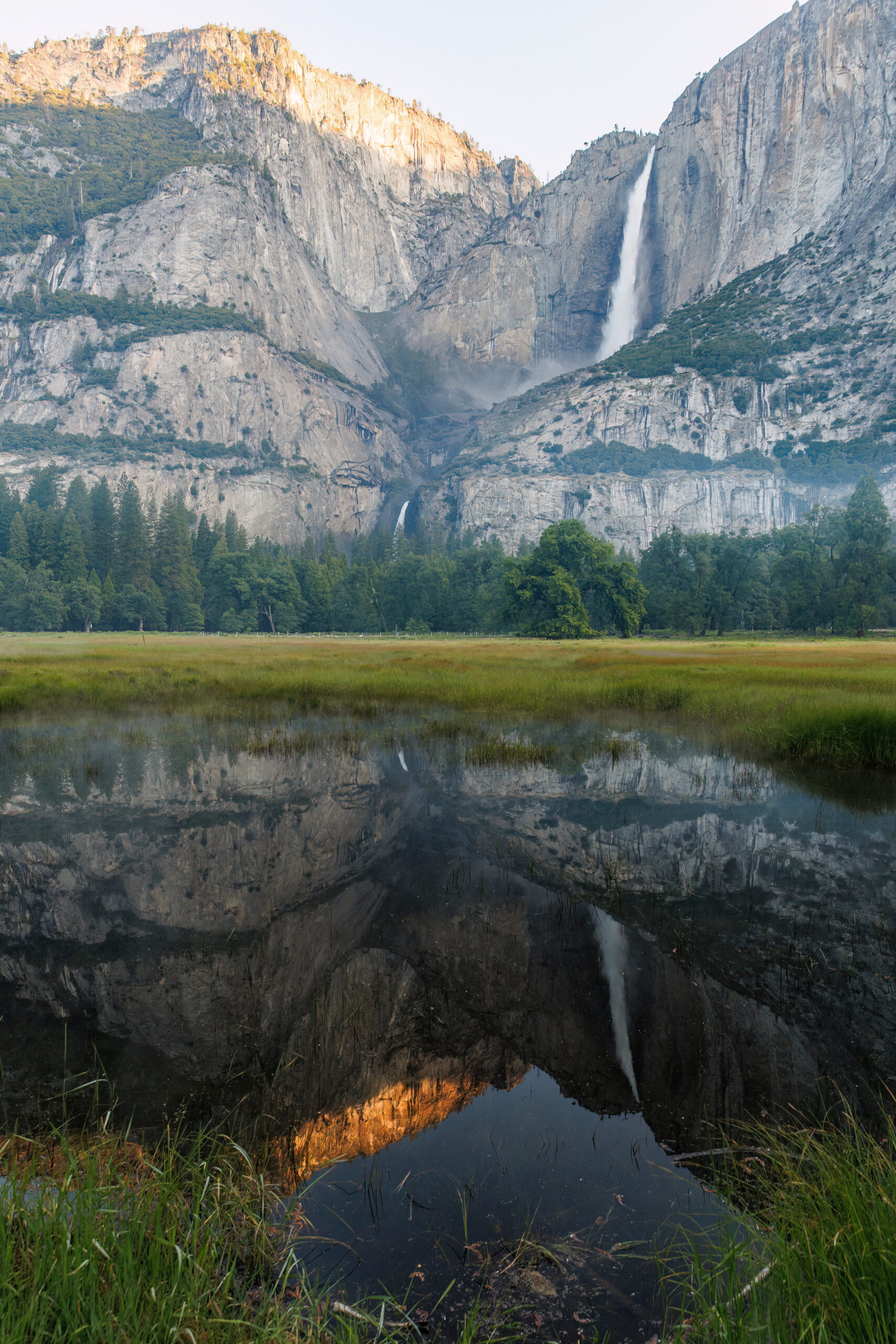 a mountain with a waterfall and it's reflection