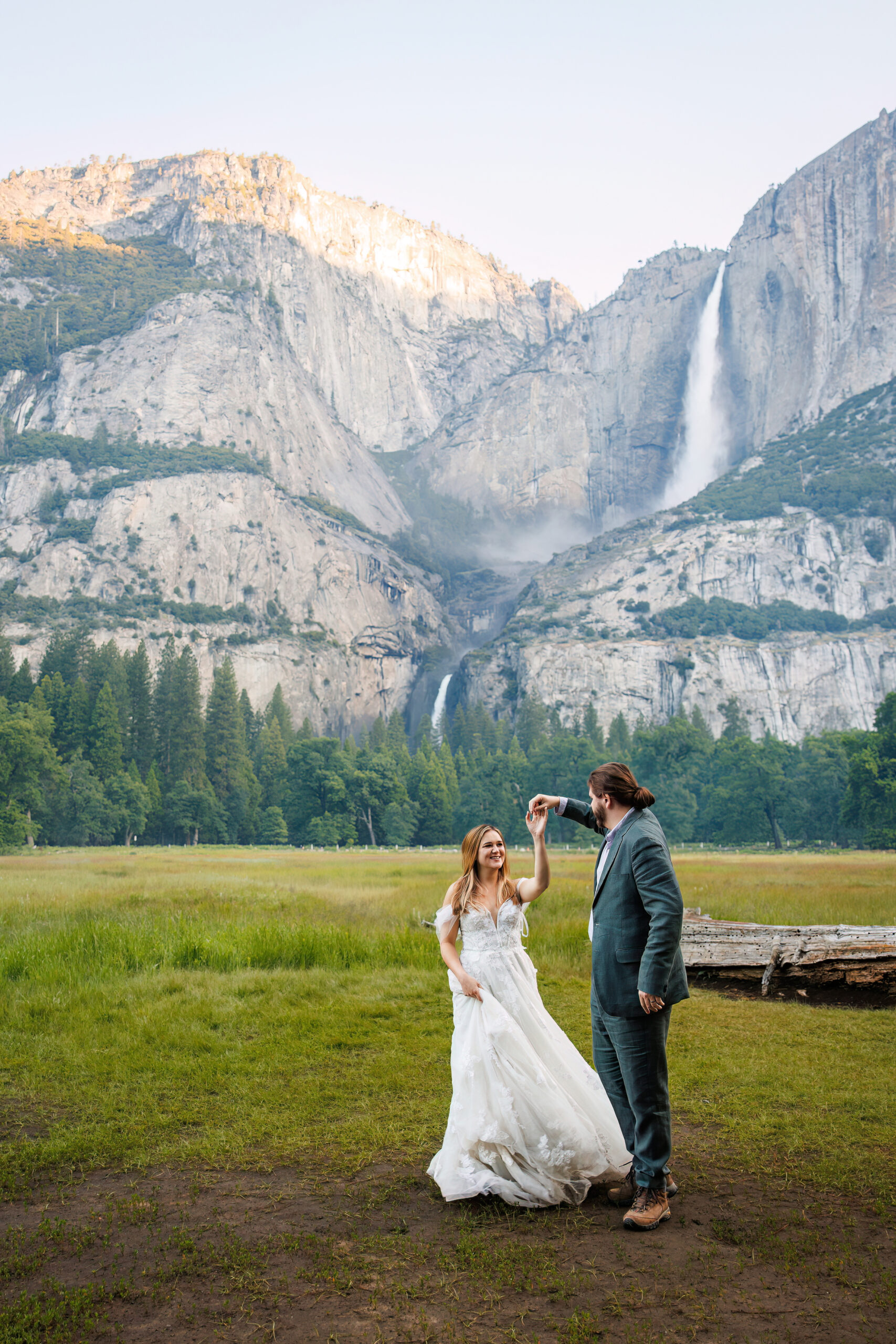 a couple dancing together in front of a waterfall in Yosemite