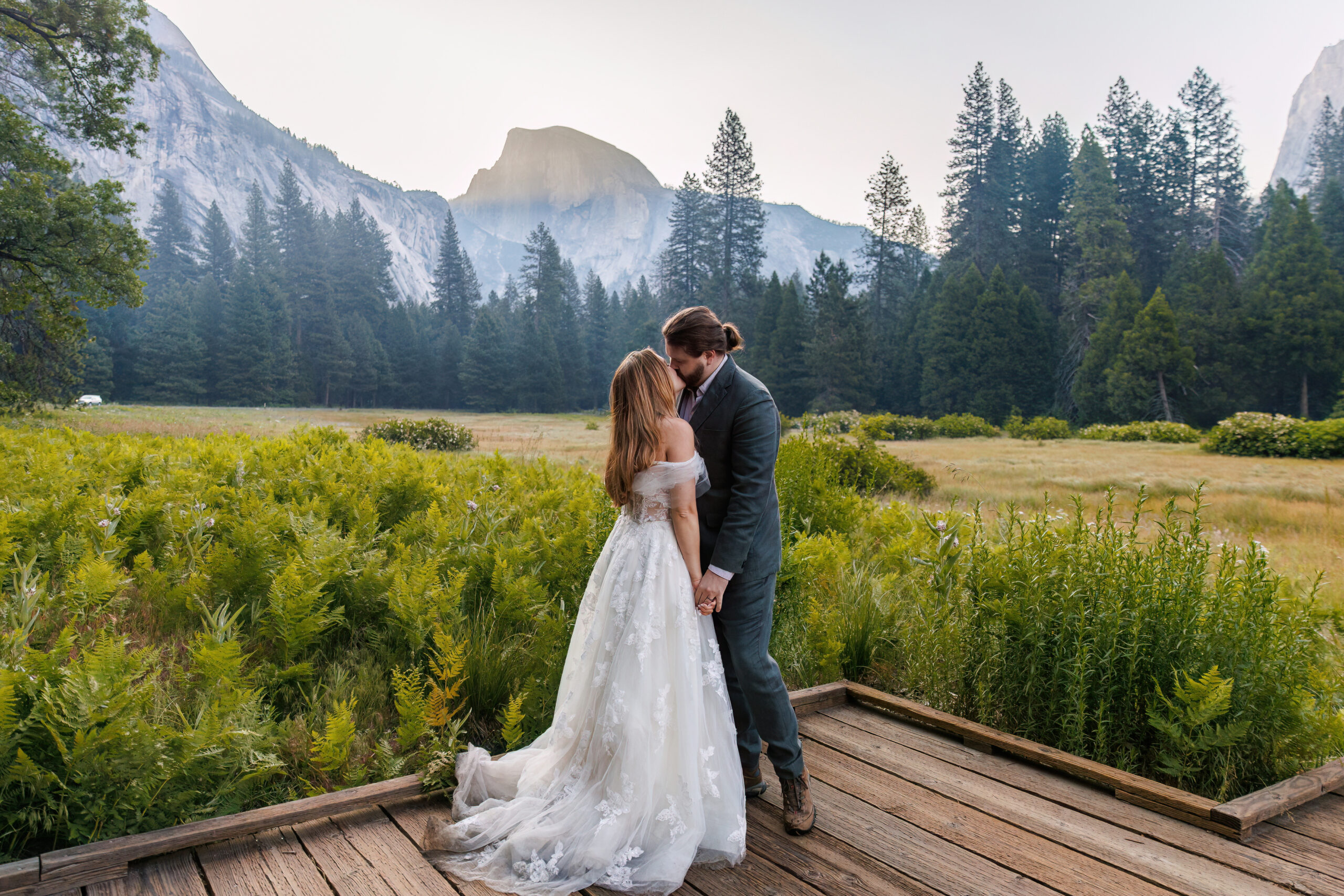 newly weds kissing in a valley at Yosemite National Park