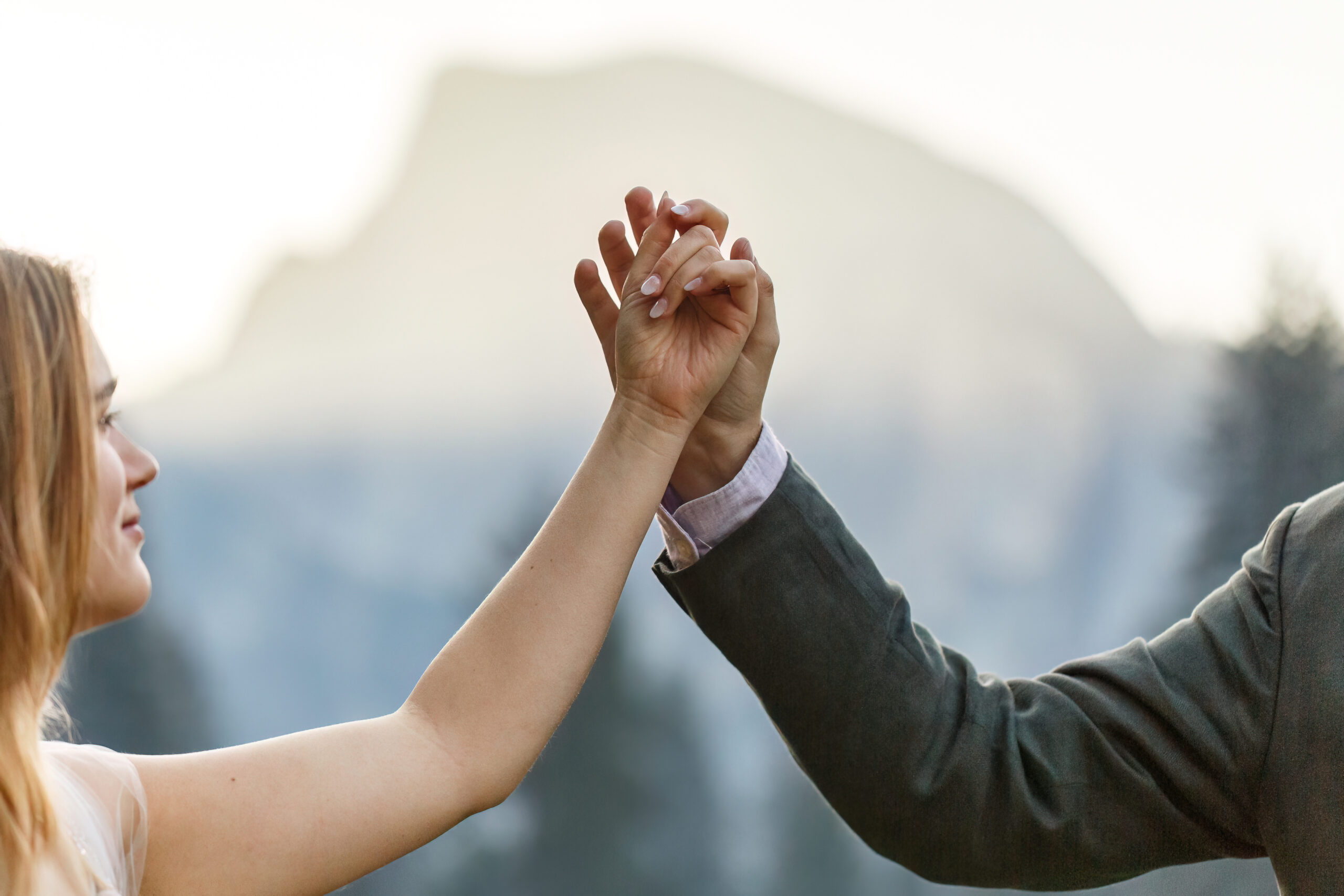 newly weds gently holding each other's hands in the air