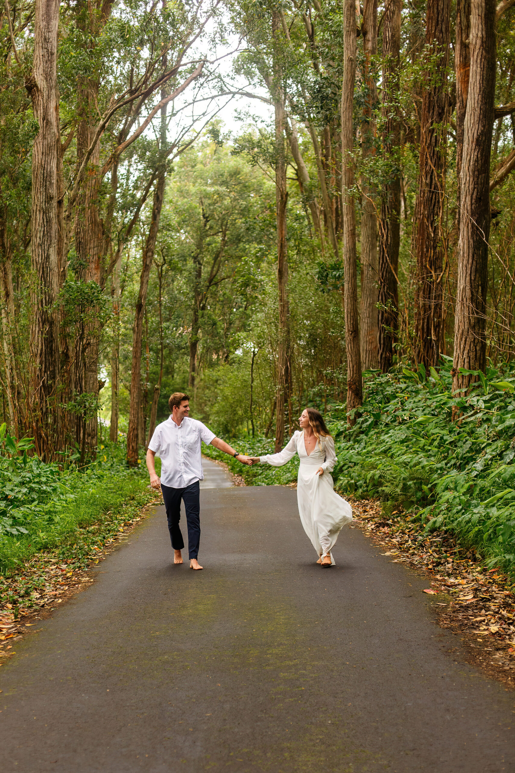 a couple walking through a tree lined path during their Hawaiian elopement