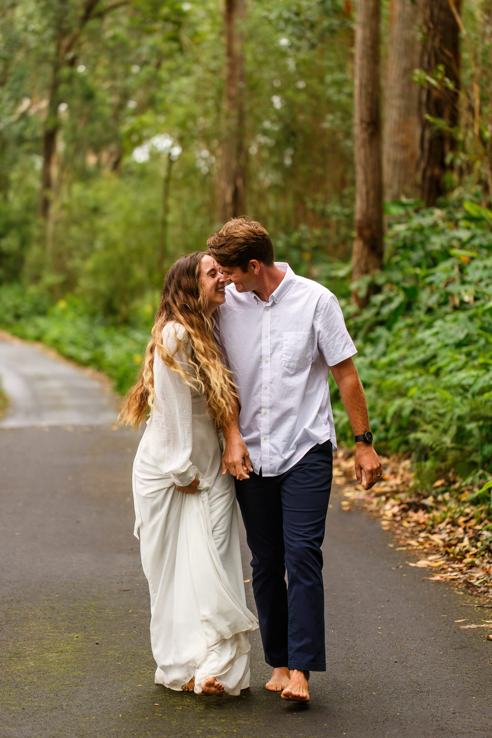 newly weds walking and smiling as they go in for a kiss in Hawaii