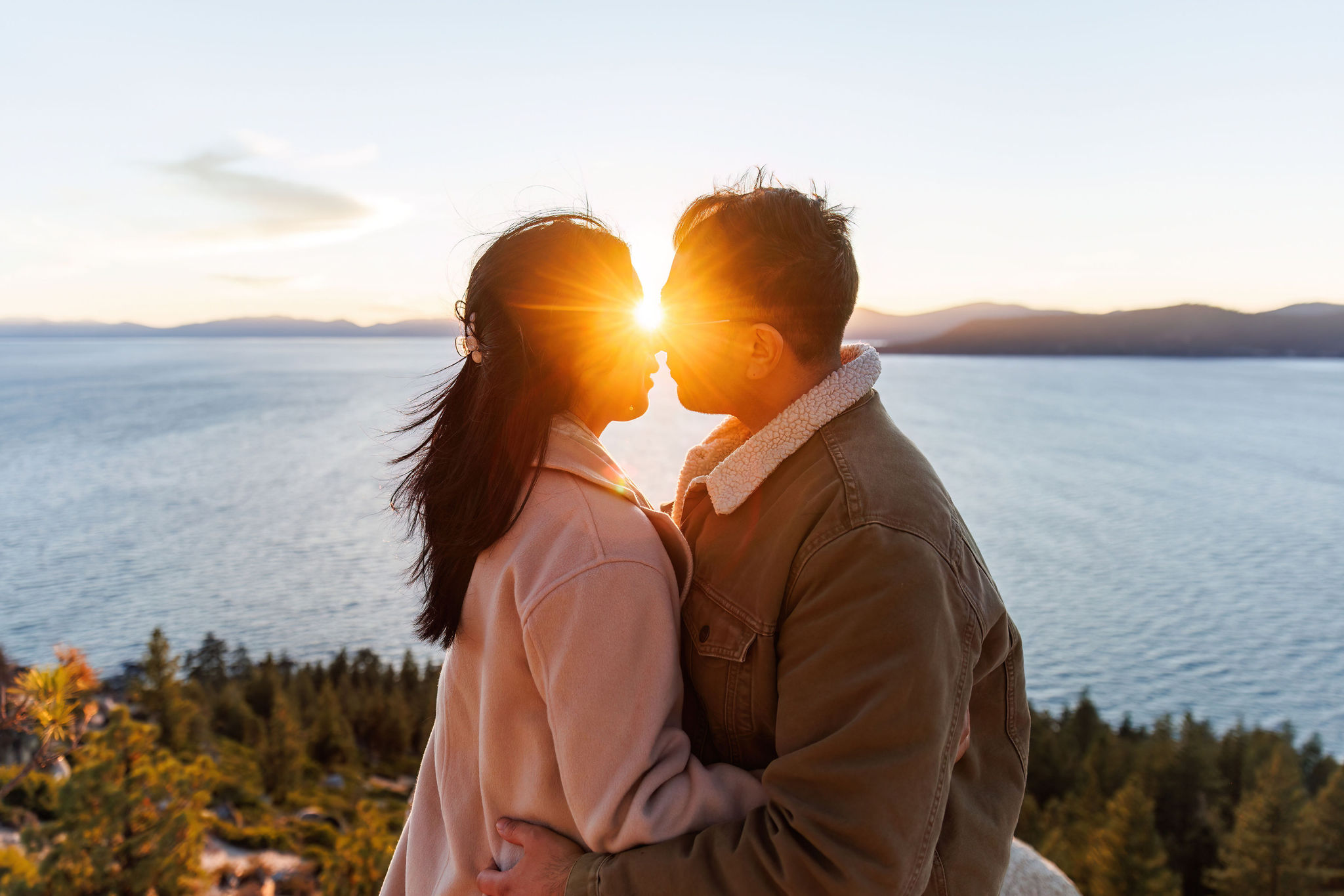 the sunset shining right between a couples face as they are about to kiss