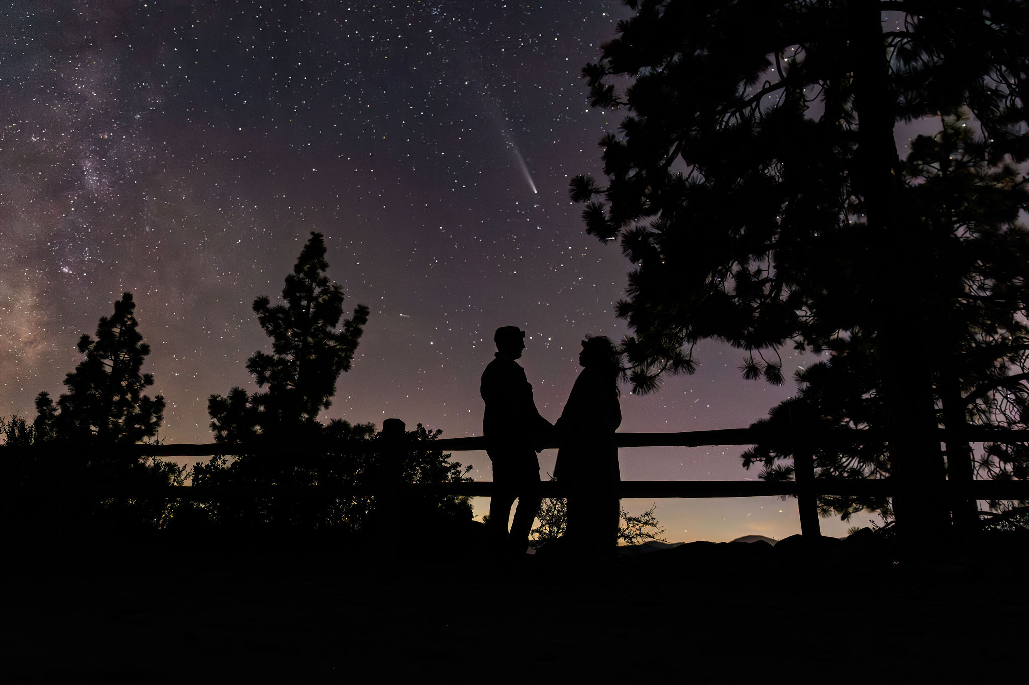 a couple holding hands with the night sky above them