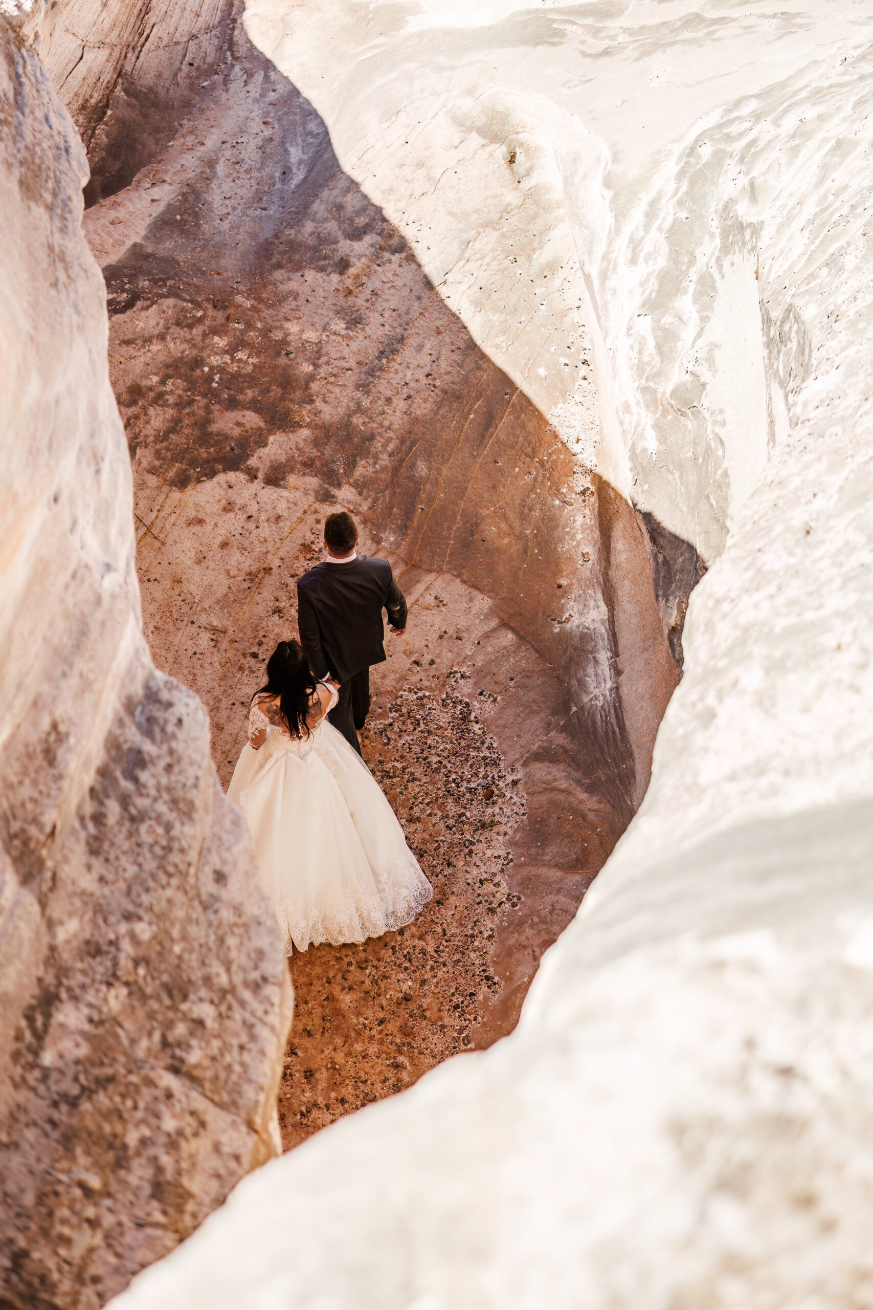 newly weds walking together through a desert canyon