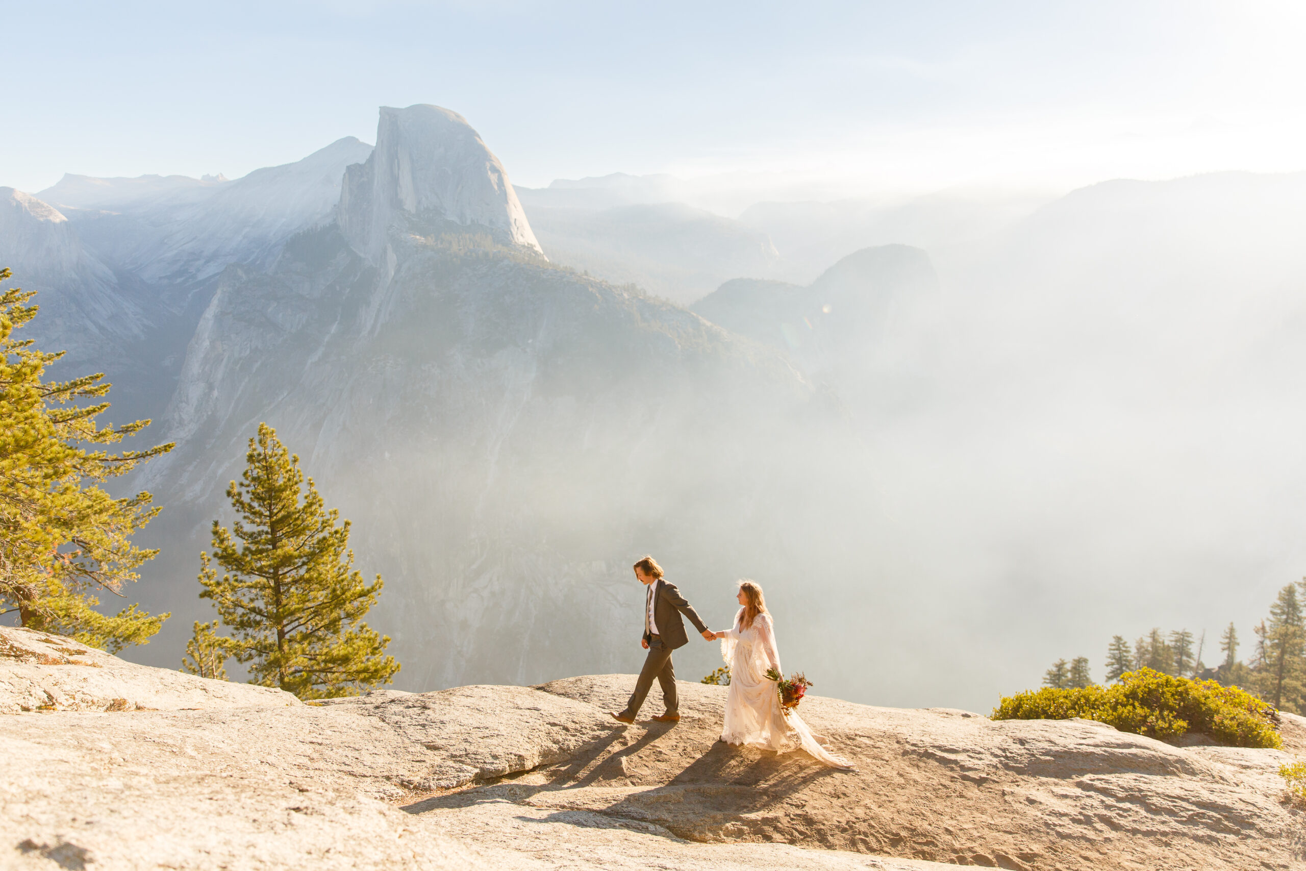 a couple walking on a rock lookout at their elopement