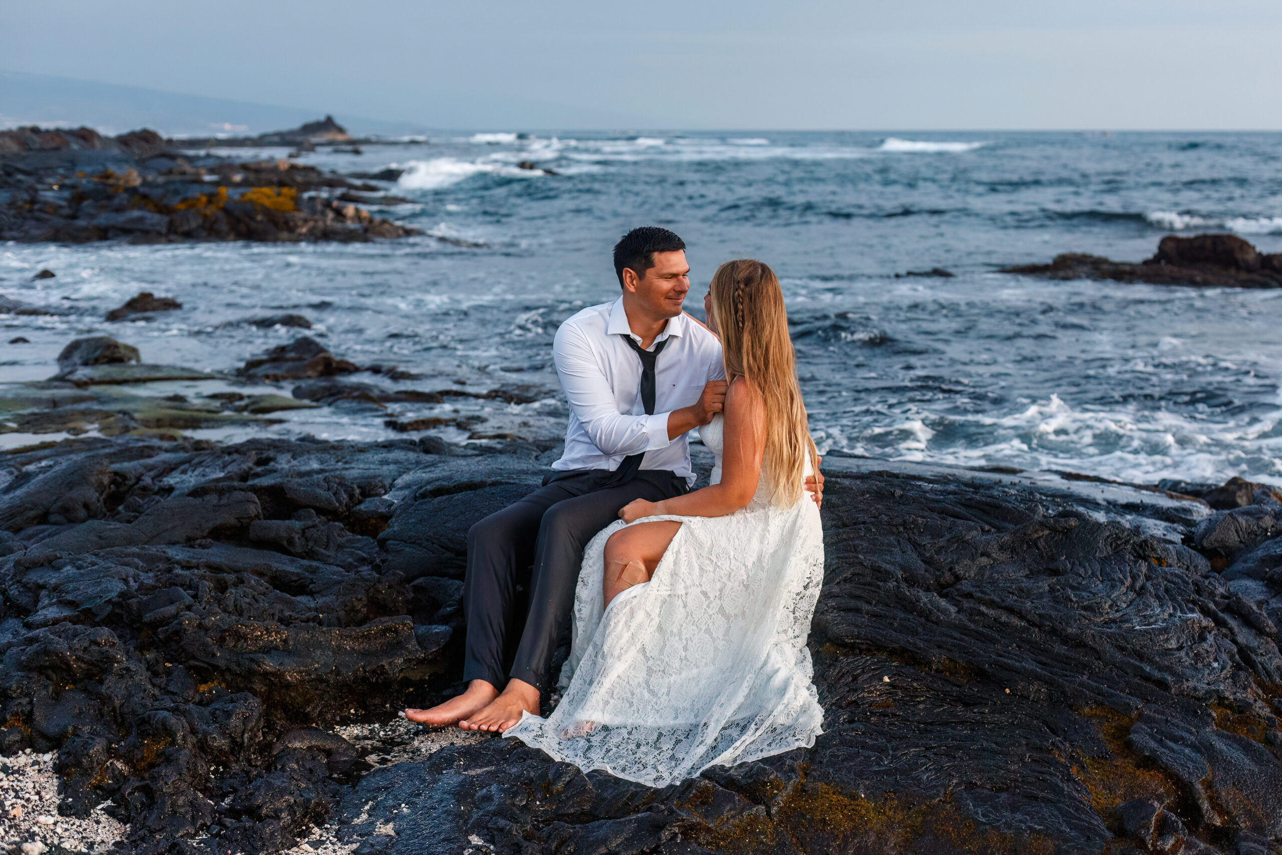 newly weds sitting on the beach in Hawaii