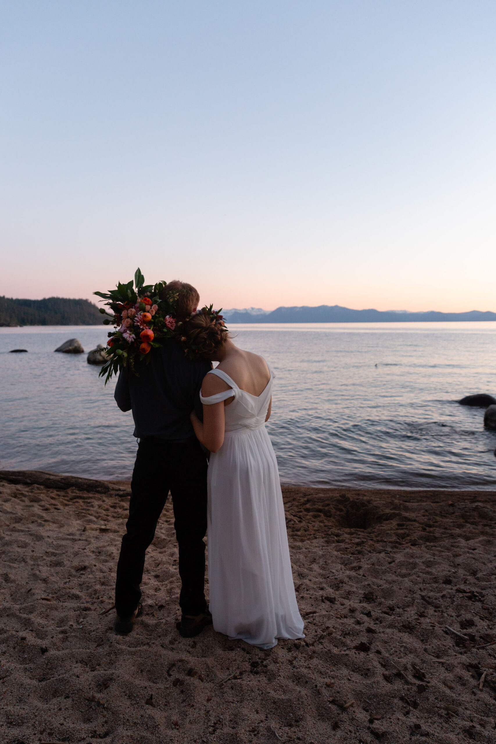 newly weds standing on a beach together during their elopement timeline