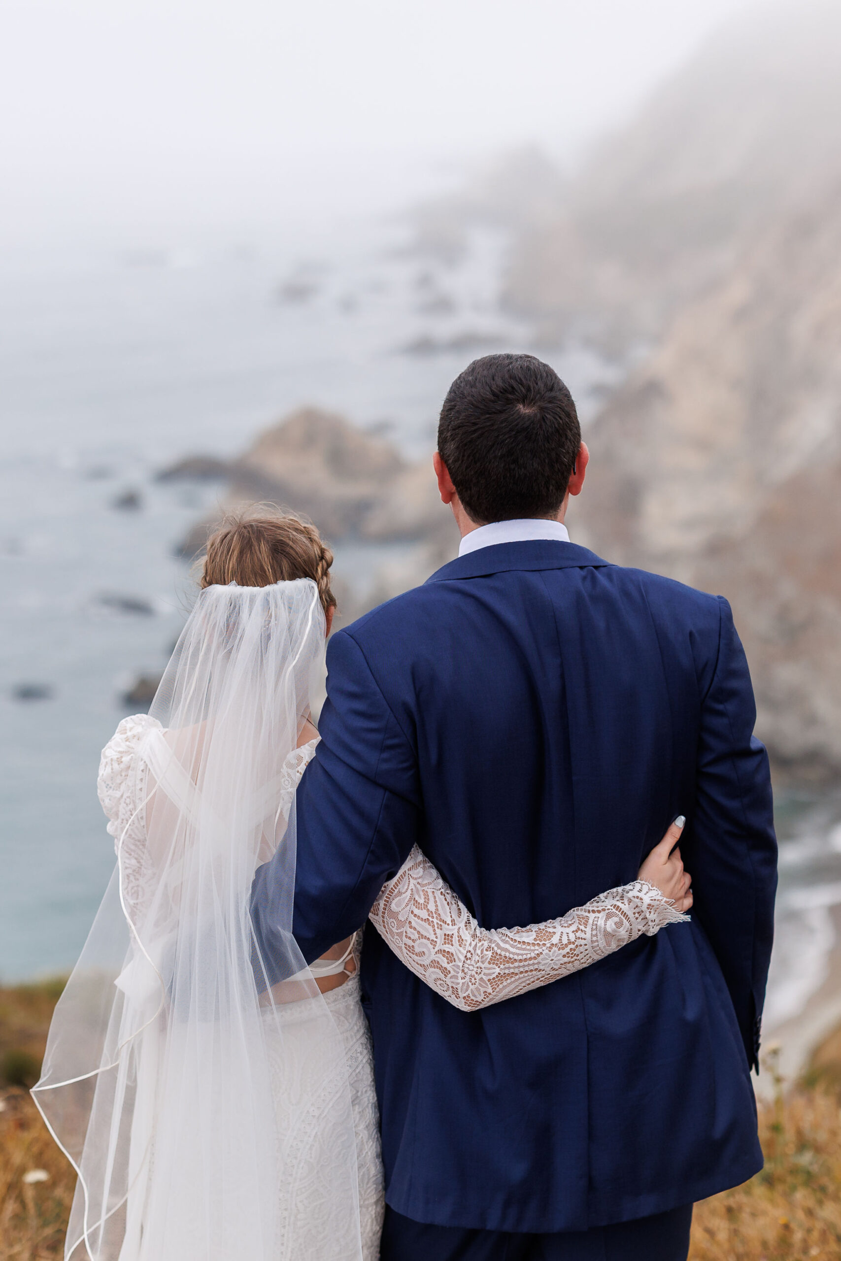 a couple looking out into the foggy ocean view during their Point Reyes elopement