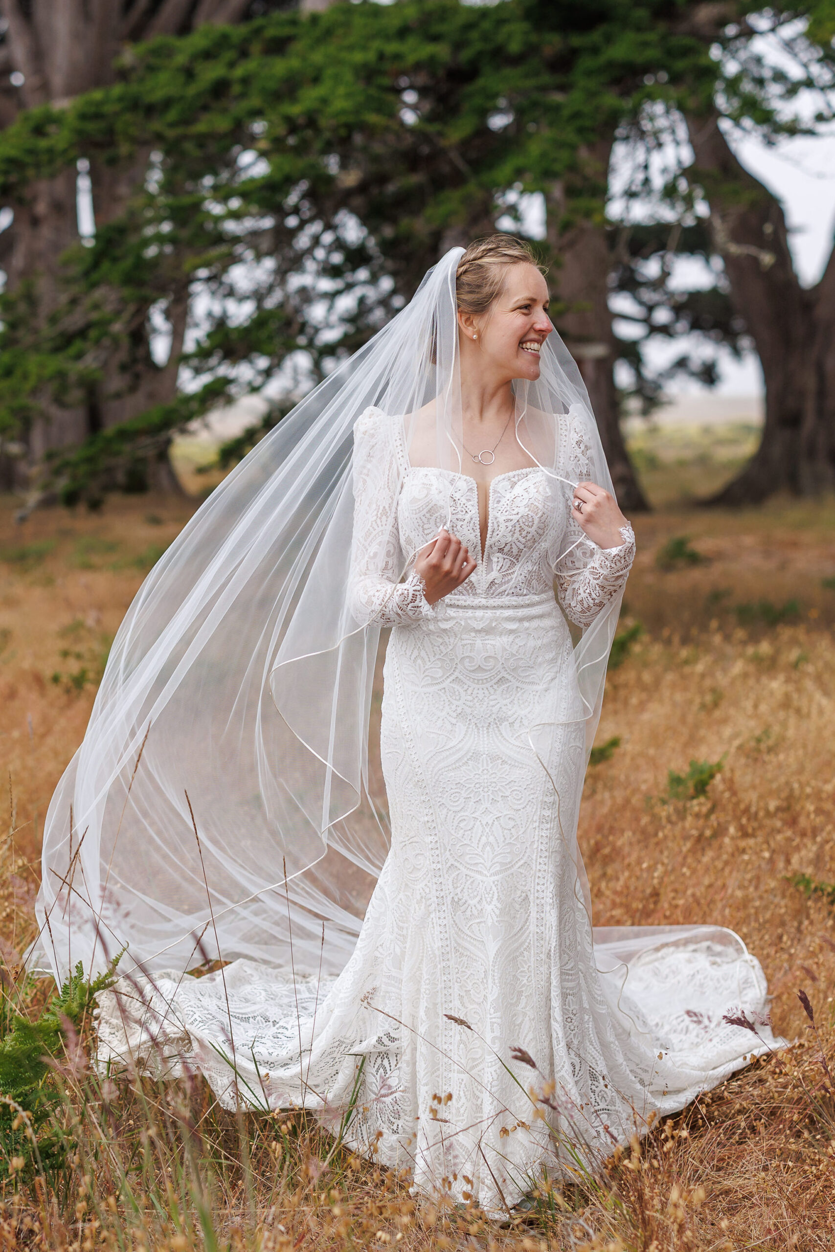 the bride smiling while holding her veil