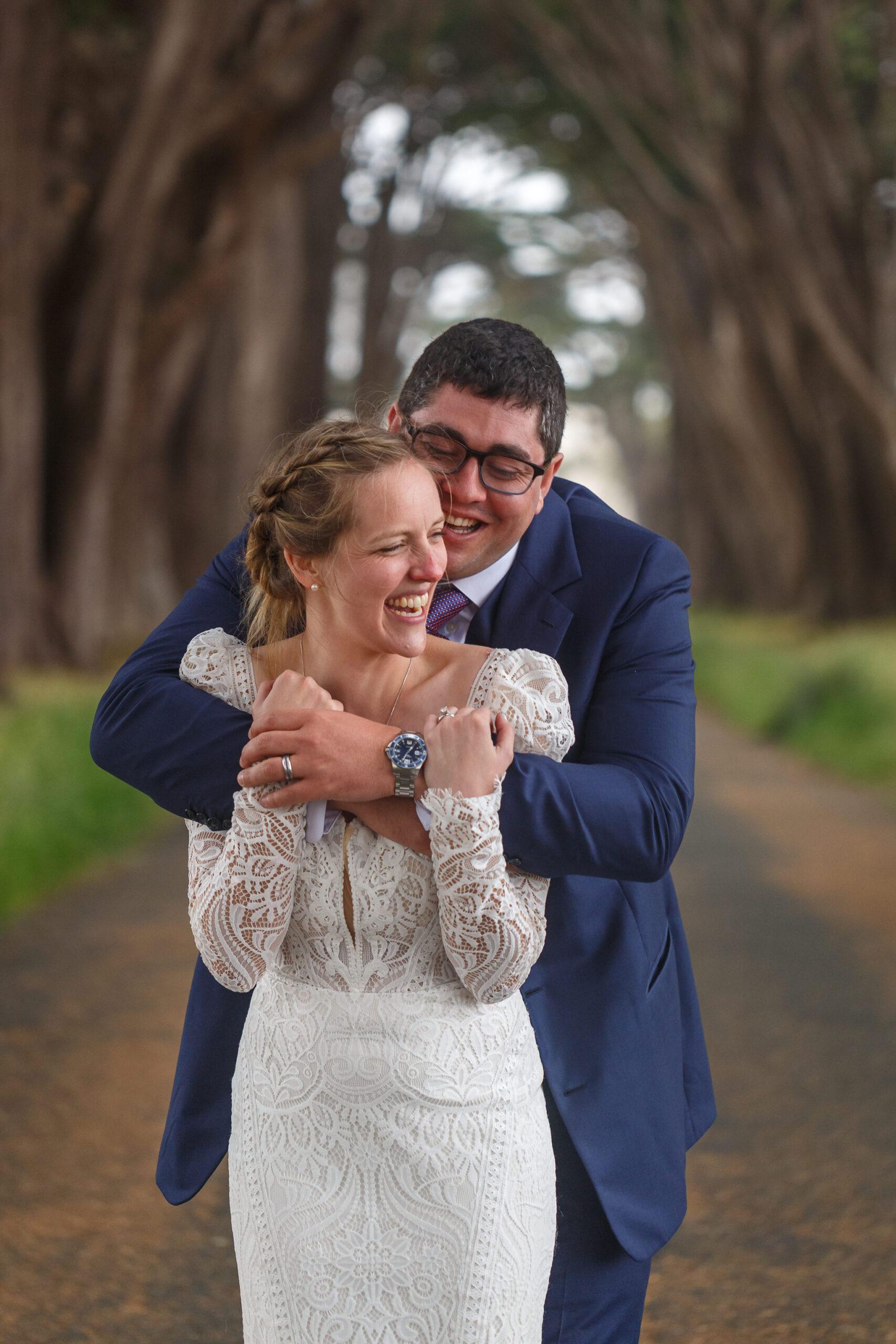a man hugging a woman from behind as they laugh together