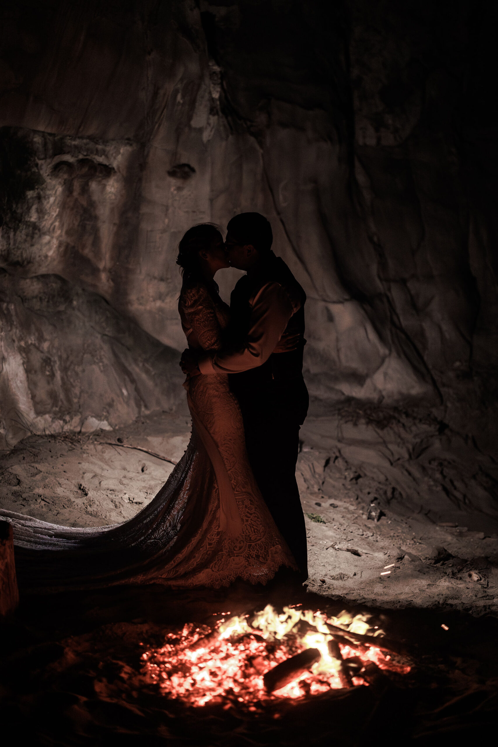 bride and groom kissing by the fire