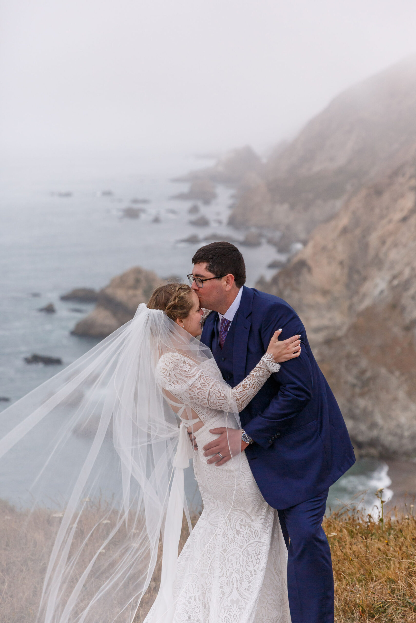 a man kissing a woman on the forehead during their Point Reyes elopement