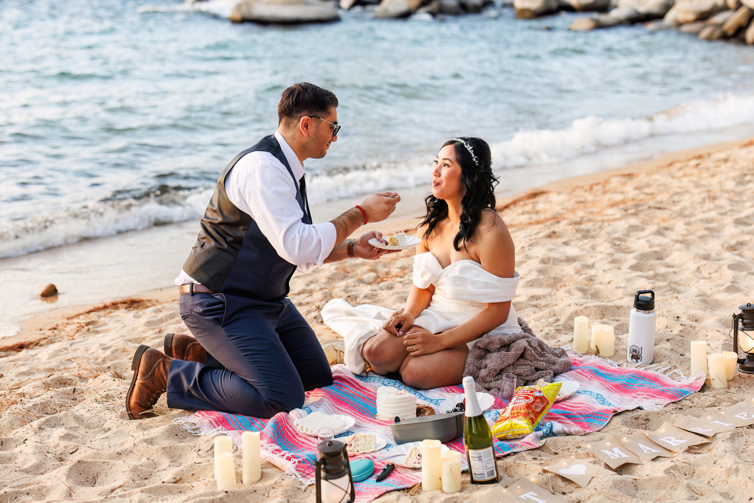 a couple having their elopement picnic on the beach in lake tahoe