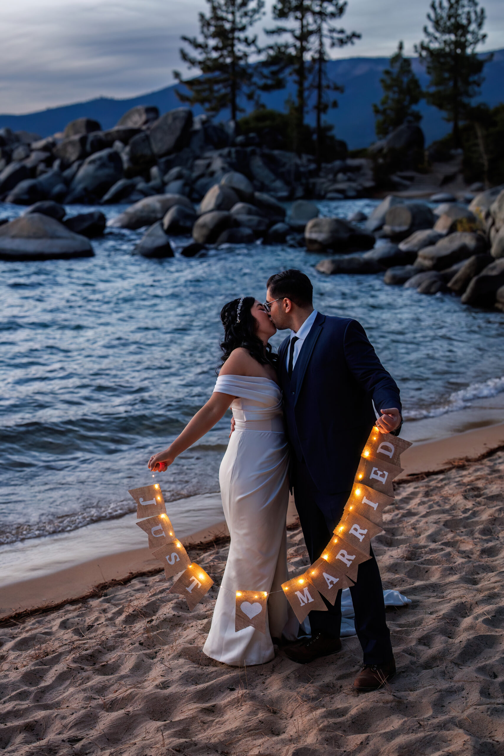 husband and wife holding up a just married sign on the beach in Lake tahoe 