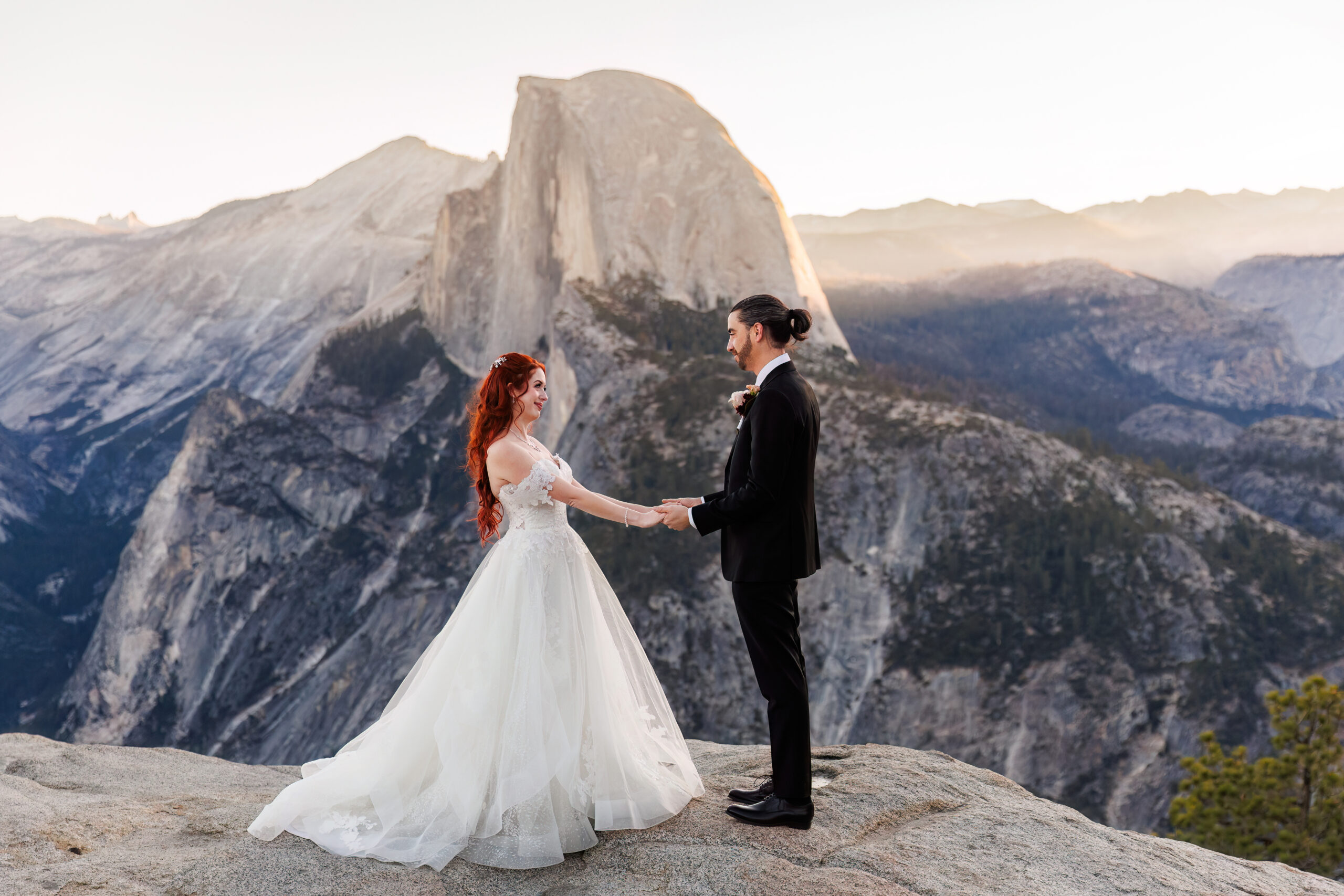 newly weds standing on an epic lookout in Yosemite 