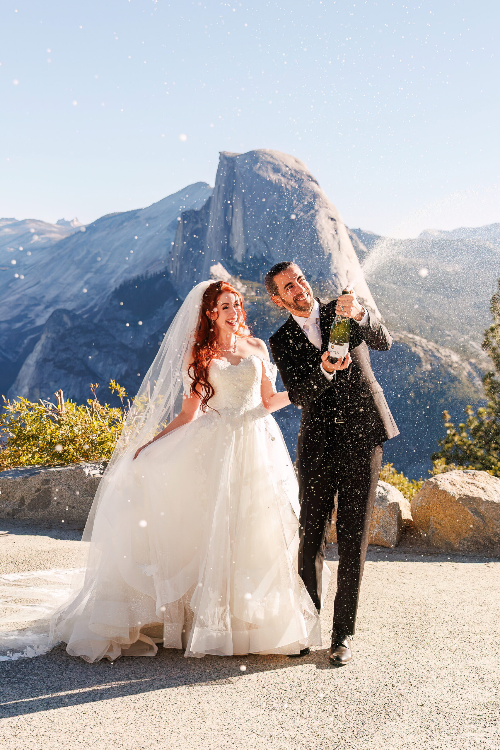 newlyweds popping champagne after their mountain elopement ceremony