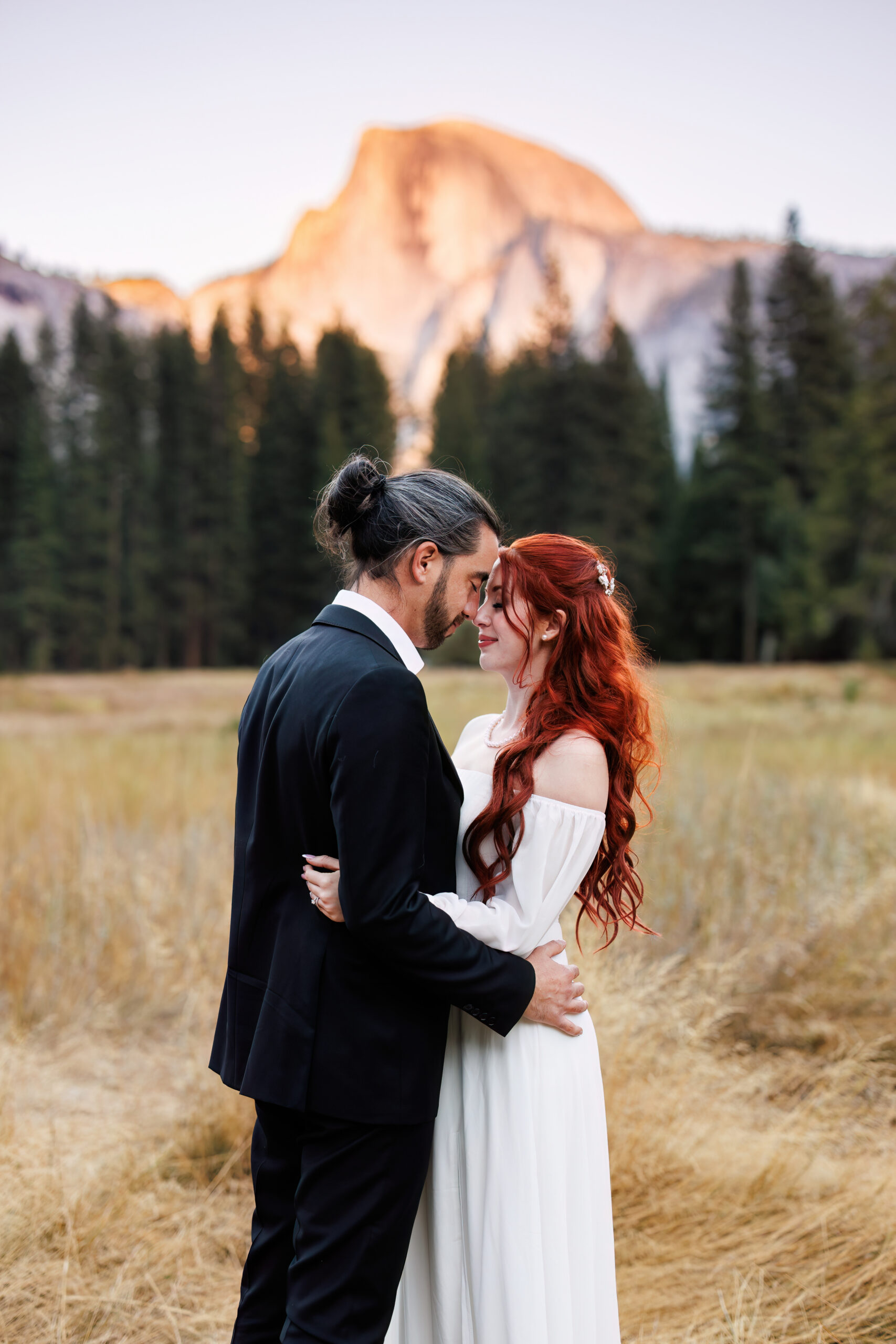 a couple standing in a meadow in Yosemite 