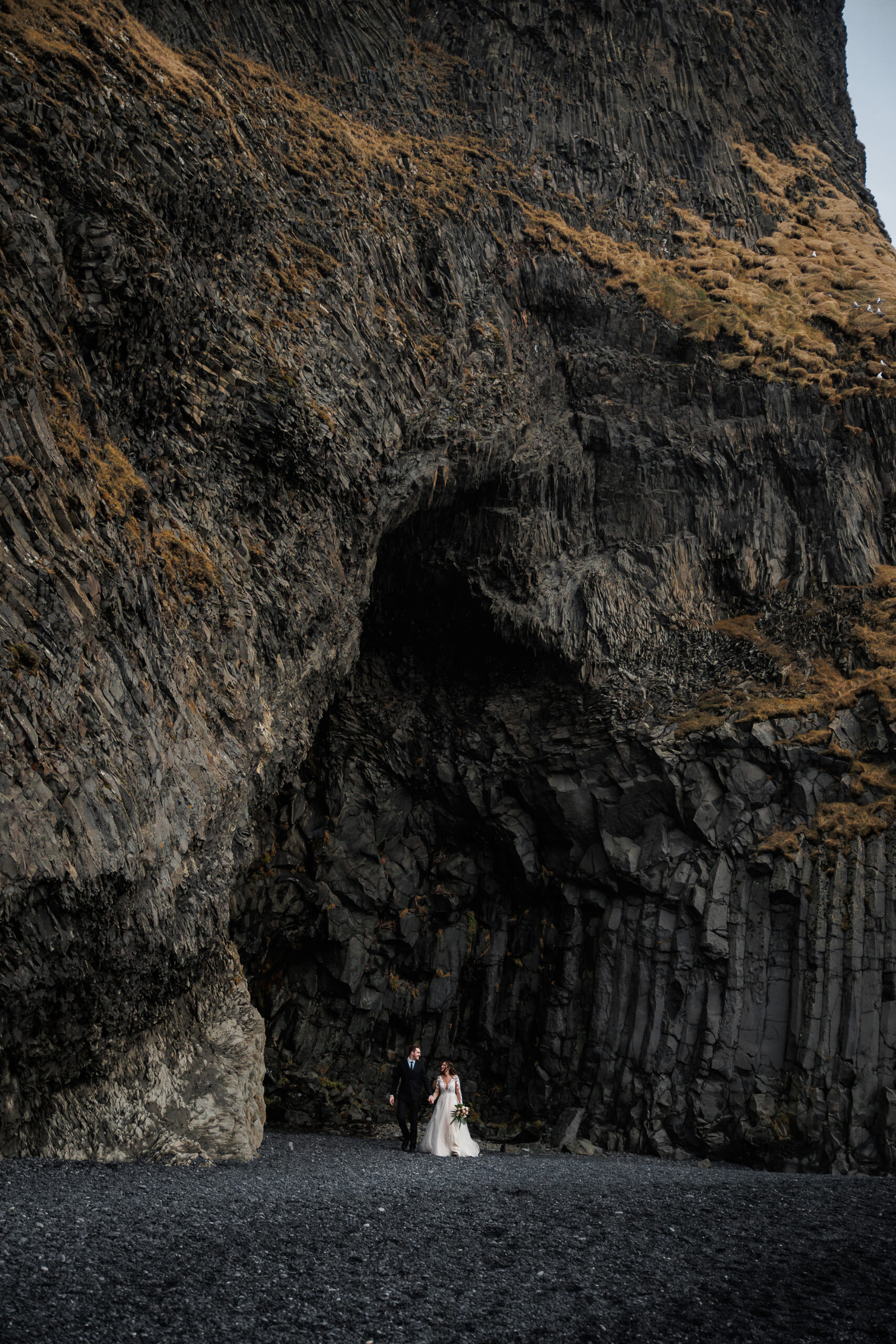 a couple on a black sand beach in Iceland during their mountain elopement 