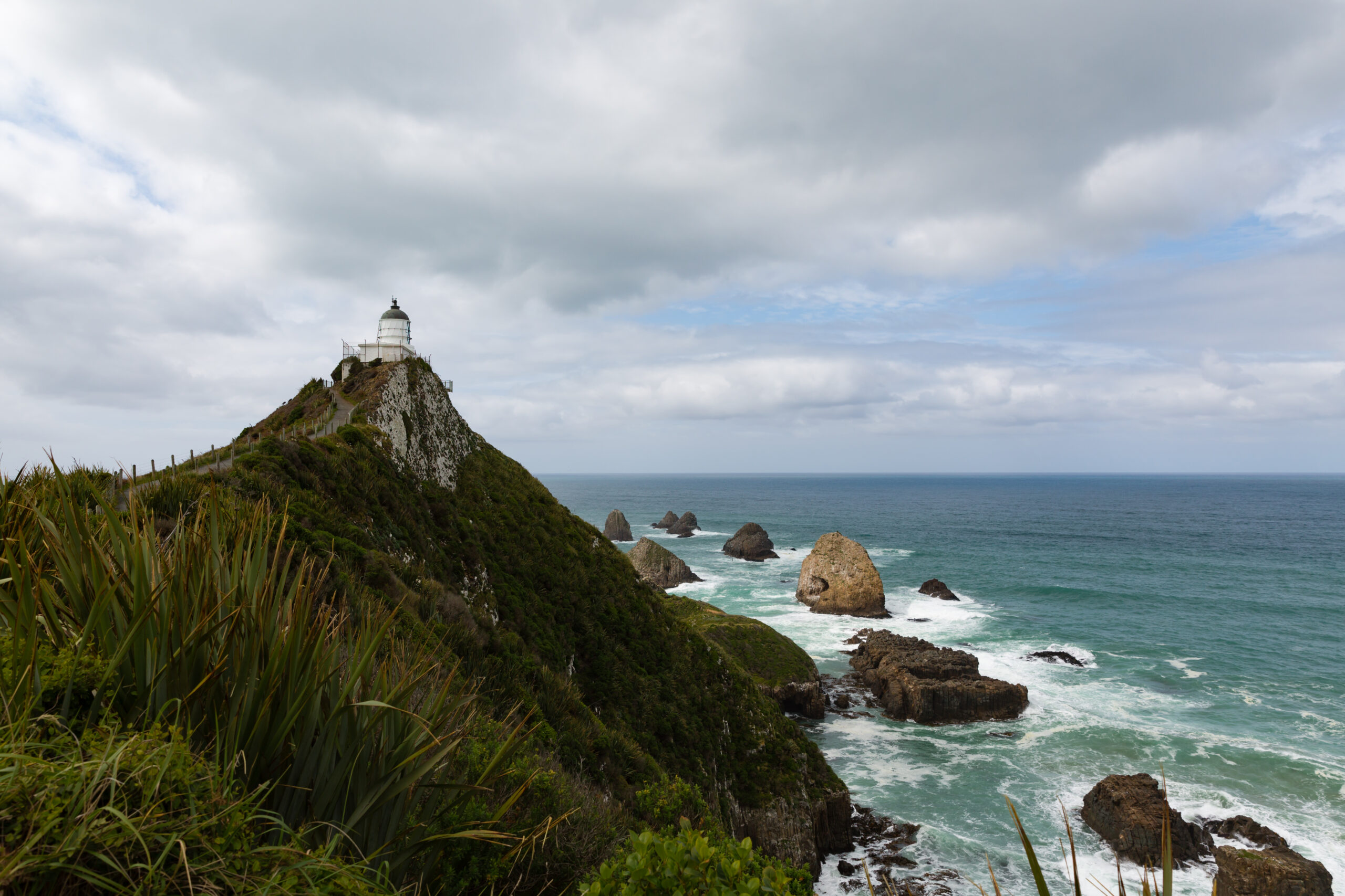 a coastal mountain with a lighthouse in NZ