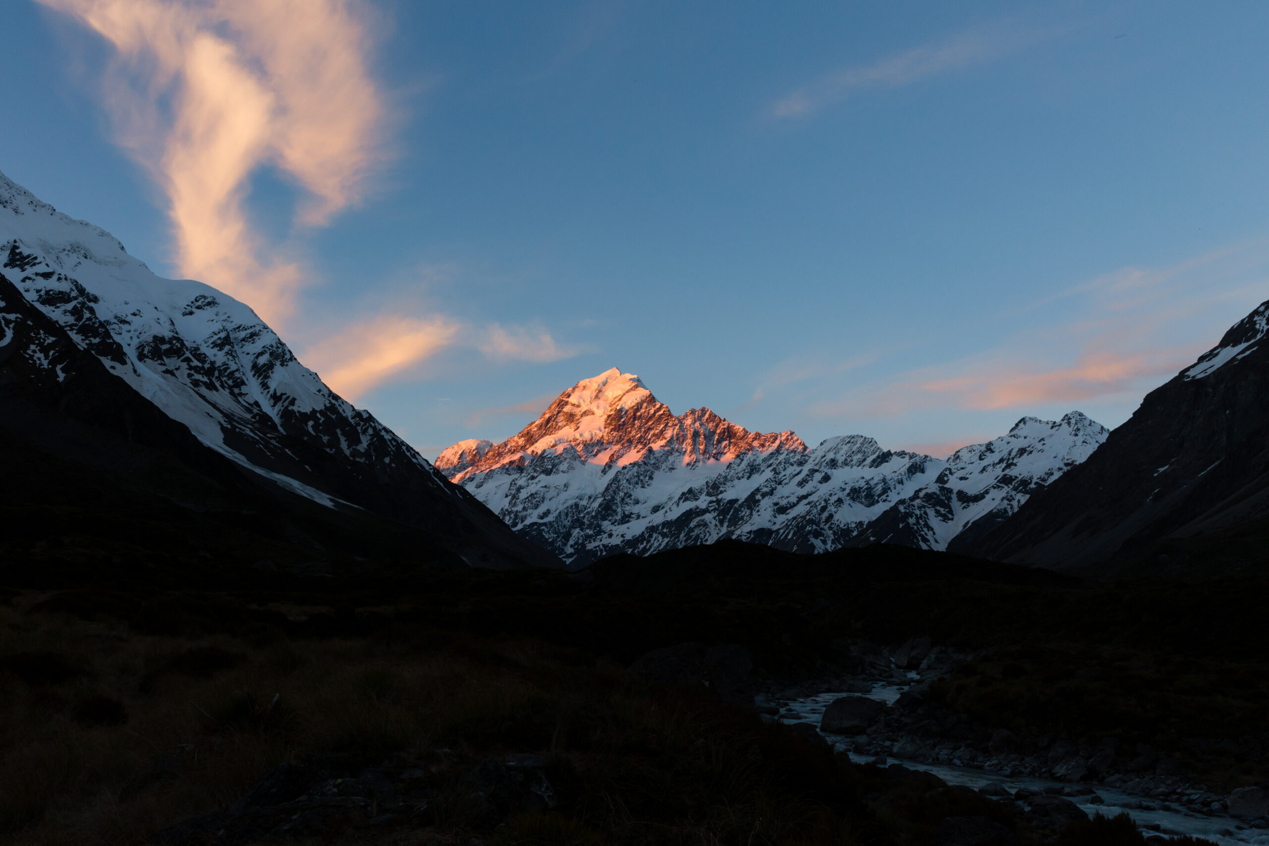 sunset shining on a snow capped mountain peak in NZ