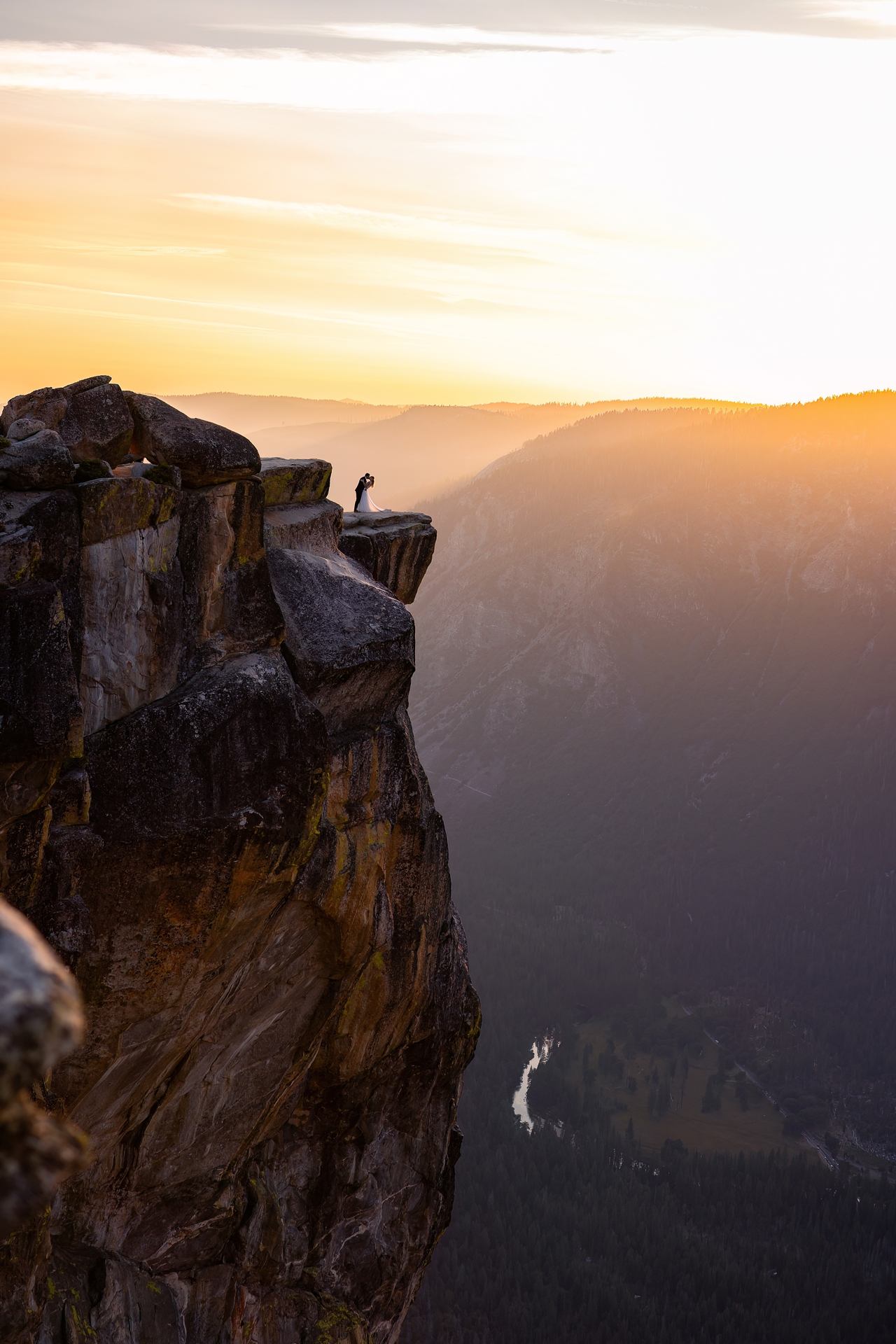 bride and groom kissing on the edge of the cliff at taft point yosemite